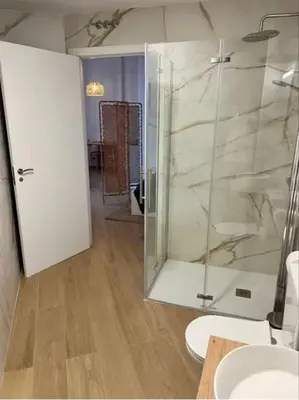 a bathroom with a glass shower and a toilet at Aqua Vida Apartments Sueca in Sueca