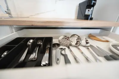 a kitchen sink with utensils in a drawer at Pinedo Playa Rustico in Valencia