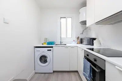 a white kitchen with a washing machine in it at Mislata Apartment in Valencia