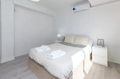 a white bedroom with a bed with towels on it at Mislata Apartment in Valencia