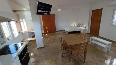 a living room with a table and a bed at Magnifico y moderno estudio bien ubicado in Valencia