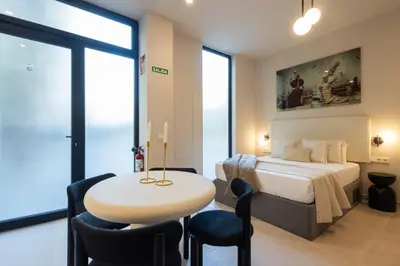 a bedroom with a bed and a table and chairs at Loft Valencia - B 1-6 Smart Access & Urban Calm in Valencia