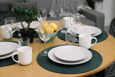 a wooden table with plates and wine glasses on it at N2 Bright & Comfortable Apartment Benicalap in Valencia