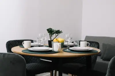 a wooden table with plates and glasses on it at N3 Bright and Cosy apartament Park Benicalap N3 in Valencia
