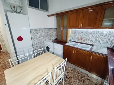 a kitchen with a wooden table and a sink at Espectacular estudio en PB con terraza privada in Valencia