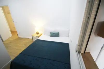 a small bedroom with a bed with a blue blanket at Apartamento Ross - Central flat with all the amenities in Valencia