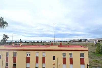 a yellow and red building with a field in the background at Vistas al Mar in Puerto de Sagunto