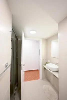 a white bathroom with a sink and a toilet at Vistas al Mar in Puerto de Sagunto