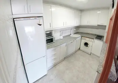 a kitchen with white cabinets and a washer and dryer at Cullera - Primera Línea de Playa in Faro de Cullera