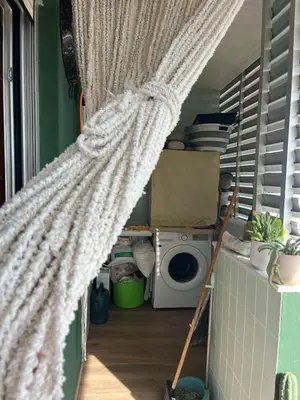 a curtain in a laundry room with a washing machine at Apartamento tranquilo y luminoso junto al mar in Cullera
