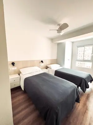 a bedroom with two beds and a ceiling at Primera línea en playa de Cullera in Cullera