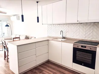 a kitchen with white cabinets and a sink and a stove at Primera línea en playa de Cullera in Cullera