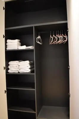 a black closet with white towels and hangers at Stylish & Cozy Flat in heart of Eixample, Valencia in Valencia