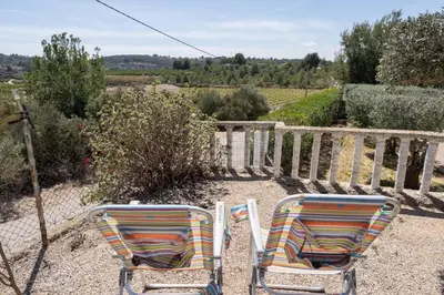 two chairs sitting on the ground next to a fence at Tiny House Long-term remote work near Valencia in Monserrat