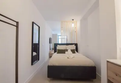 a bedroom with a bed with a mirror and a television at NOMAD Viveros 02 in Valencia