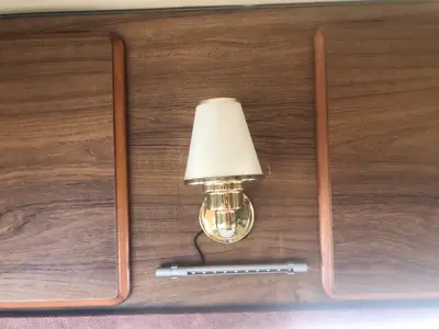 a light attached to a wooden wall with a lamp at Autocaravana in Port Saplaya