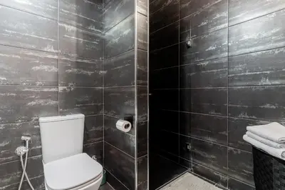 a bathroom with a toilet and black tiled walls at Modern 2BR Apartment with Terrace in Valencia in Valencia