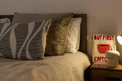 a bed with two pillows and a sign on a table at República Argentina 02 in Valencia