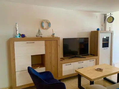 a living room with a tv and a wooden entertainment center at Casa Pera in Chilches