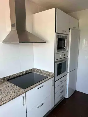 a white kitchen with a sink and a stove at Triton in Mareny Blau