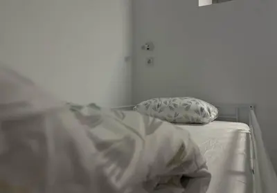 an unmade bed with a pillow and sheets on it at Hostel valencia ruzafa in Valencia