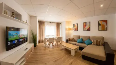 a living room with a couch and a tv at Apartamento moderno en el centro de Tavernes in Tavernes de Valldigna