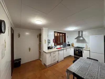 a kitchen with white appliances and a table in it at Albalat Centro in Albalat de la Ribera