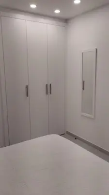 a white room with white cabinets and a bed at Iberflat Apartamentos Alfabega in Paterna