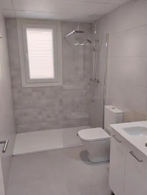 a bathroom with a shower and a toilet and a window at Iberflat Apartamentos Alfabega in Paterna