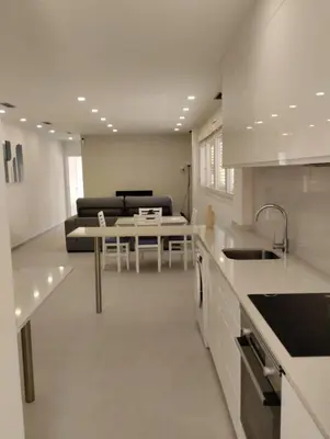 a kitchen and living room with a table and a couch at Iberflat Apartamentos Alfabega in Paterna