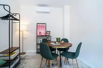 a dining room with a table and green chairs at Republica Argentina 1 in Valencia
