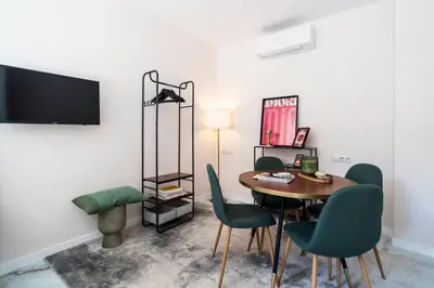 a dining room with a table and green chairs at Republica Argentina 1 in Valencia