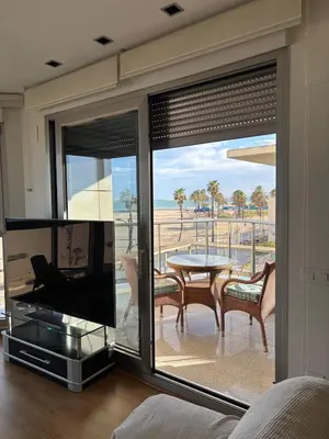 a living room with a large window with a tv and a table at Relaxing Sea View Apartment - Patacona Beach in Valencia