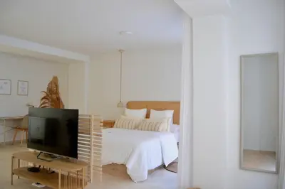 a white bedroom with a bed and a television at Excepcional moderno y luminoso Terraza privada in Valencia