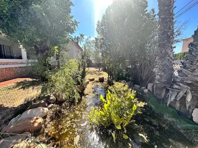 a backyard with a pond with rocks and trees at Casa Mar in Valencia