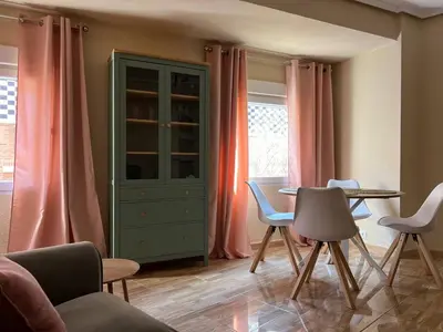 a living room with pink curtains and a table and chairs at Pearl by the sea in Valencia