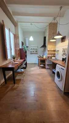 a large kitchen with a table and a washing machine at Casita Buenos Aires in Valencia