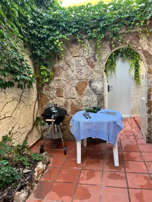 a grill and a table on a patio at Casa Enredadera in Mareny Blau