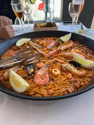 a pan of seafood pasta with shrimp and lemon slices at Casa Enredadera in Mareny Blau