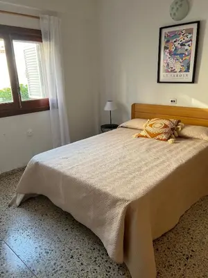 a large bed in a bedroom with a window at Casa Enredadera in Mareny Blau