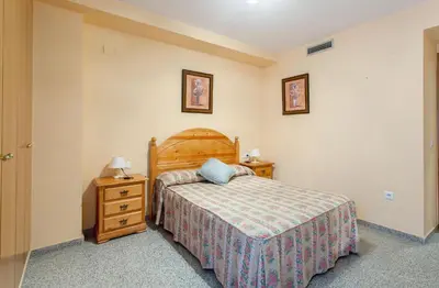 a bedroom with a bed and a nightstand and a bed sidx sidx sidx sidx at Apartment Patacona Beach 7 in Valencia