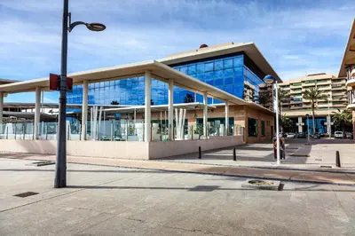 a large building with glass windows on a street at Apartment Patacona Beach 7 in Valencia