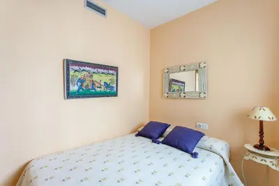 a bedroom with a bed with blue sheets and a mirror at Apartment Patacona Beach 6 in Valencia