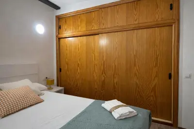 a bedroom with a wooden cabinet and a bed at Mini Peixcateria in Sagunto