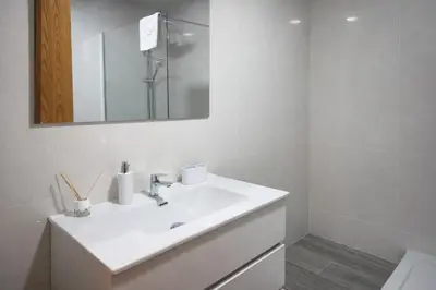 a white bathroom with a sink and a mirror at Mini Peixcateria in Sagunto