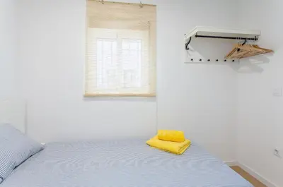 a bedroom with a bed with a yellow towel on it at Apartment Ruzafa Puerto Rico in Valencia