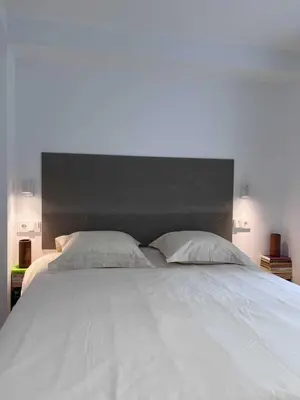 a large white bed with a black headboard and two pillows at Centro Histórico - Beneficencia Flat in Valencia