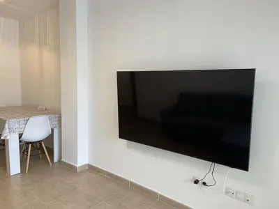 a flat screen tv hanging on a white wall at Dream Moncofar in Moncófar