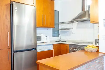 a kitchen with a stainless steel refrigerator and wooden cabinets at Valencia Flat Rental 1 bedroom apartment historical center in Valencia