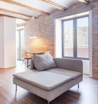a couch in a living room with a brick wall at superincreible ubicación in Valencia